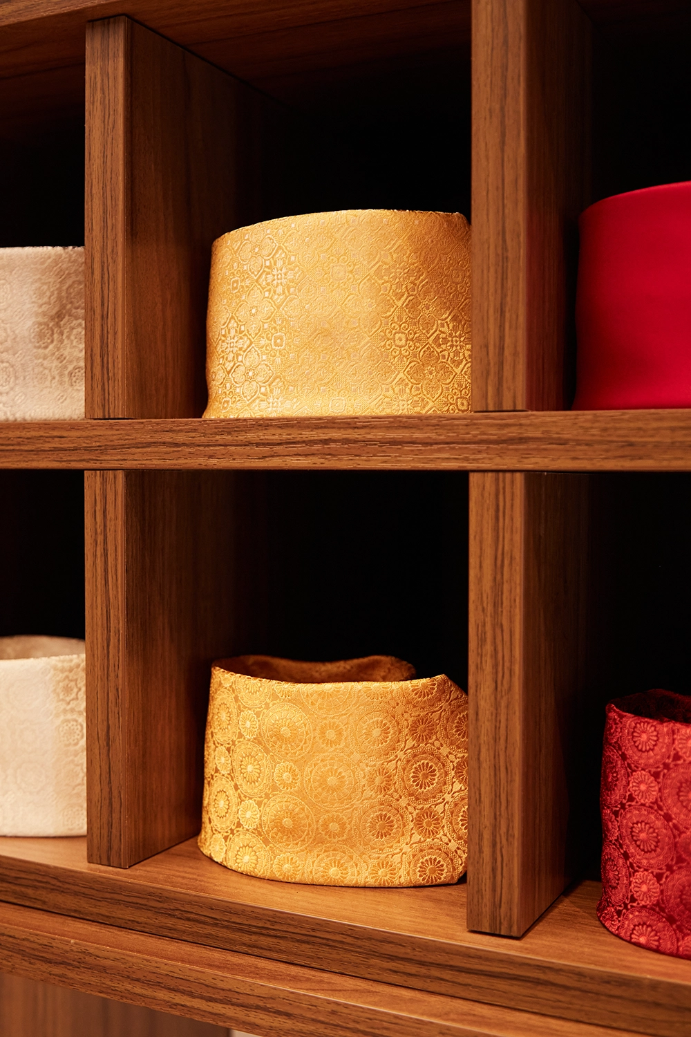 Folded jacquard silks in saffron, ivory, and crimson